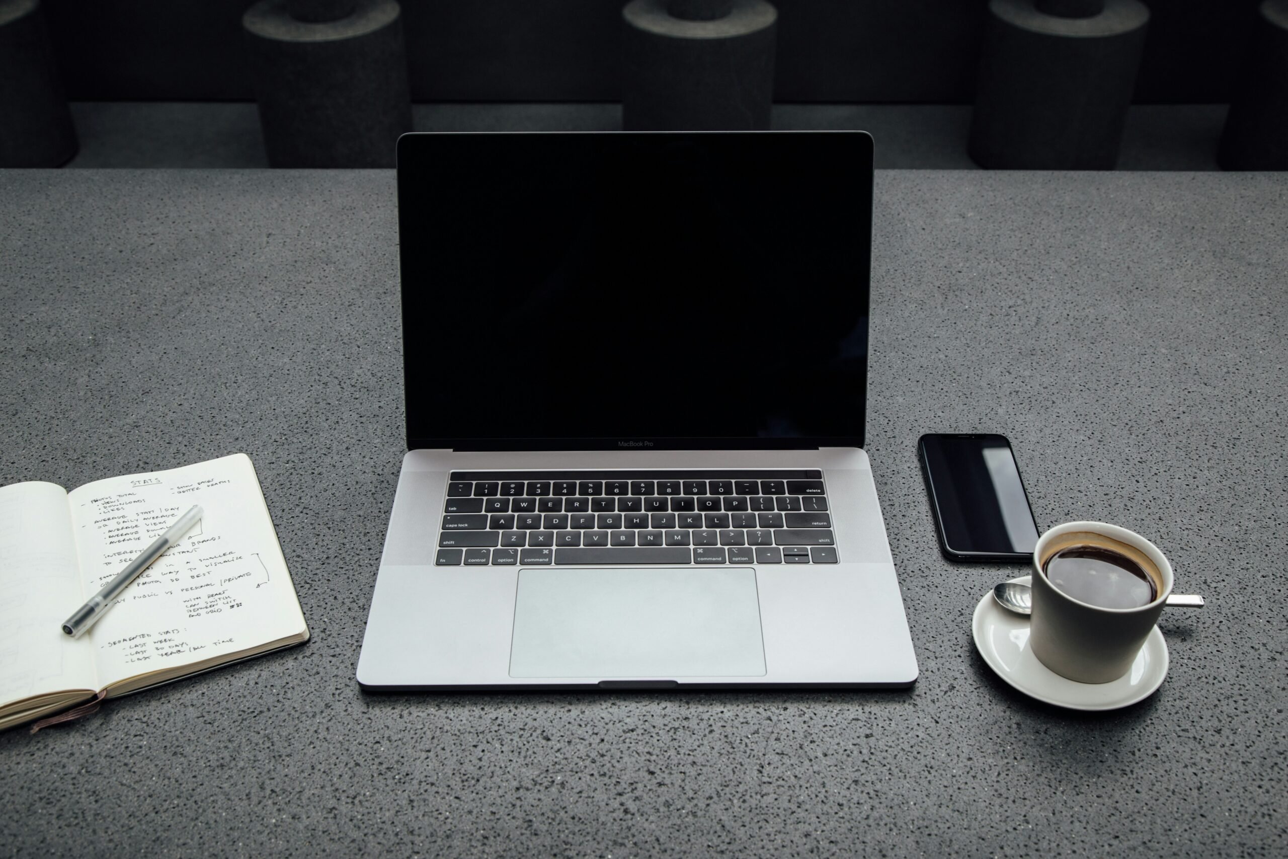 A frustrated marketer surrounded by papers, laptops, and coffee cups